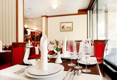 a table with wine glasses and napkins on it at Hotel COOP, Sofia in Sofia