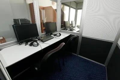 an office with three computer monitors on a desk at Hotel COOP, Sofia in Sofia