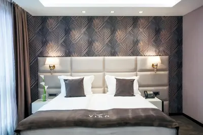 a bedroom with a large bed with a large headboard at VIKO Boutique Apart Hotel in Sofia