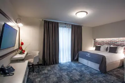 a hotel room with a large bed and a television at VIKO Boutique Apart Hotel in Sofia