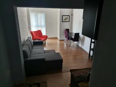 a living room with a couch and a red chair at Vila Nova in Sandanski