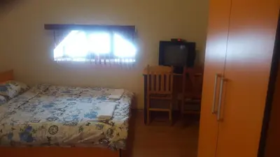 a bedroom with a bed and a window and a television at Guest House - Batak in Batak