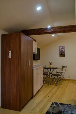 a kitchen with a large wooden cabinet and a table at Guest House Vasilena Самостоятелно наемане FREE PARKING in Sapareva Banya