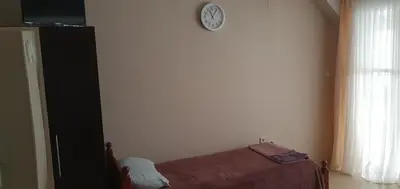 a bedroom with a bed and a clock on the wall at Rooms Lagat in Troyan