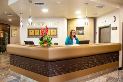 a woman talking on a phone at a reception desk at Balneo Complex & Spa Aquatonik in Velingrad