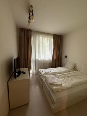 a bedroom with a bed and a television on a table at PM Services Borovets Garden Apartments in Borovets