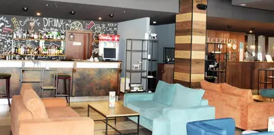 a lobby with couches and a bar with a counter at PM Services Borovets Garden Apartments in Borovets