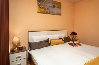 a bedroom with a large white bed with pillows at MIDAS - Borov Park in Velingrad