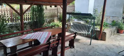 a wooden table and bench under a gazebo at Guest House Lazar Raykov in Ribarica