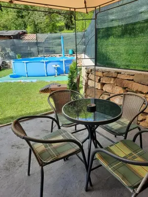 a patio with a table and chairs and a pool at Guest House Lazar Raykov in Ribarica