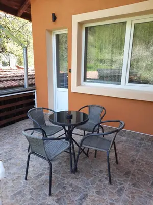 a black table and chairs on a patio at Guest House Lazar Raykov in Ribarica