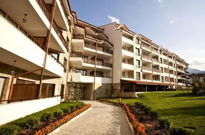a large apartment building with a pathway in front of it at Parklands Hotel & Pool in Bansko