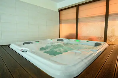 a large bath tub in a room with a window at Parklands Hotel & Pool in Bansko