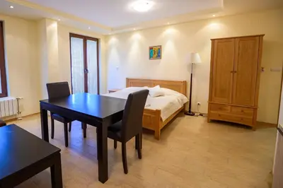 a bedroom with a table and a bed and a table and chairs at Parklands Hotel & Pool in Bansko