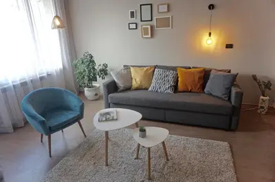 a living room with a couch and a table and a chair at Sofia City Home in Sofia