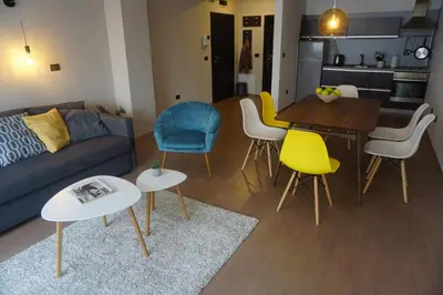 a living room with a couch and a table and chairs at Sofia City Home in Sofia