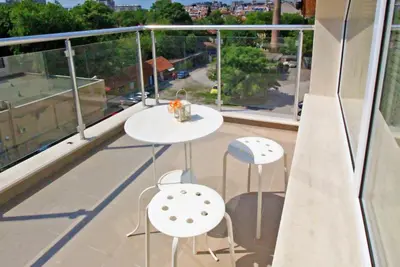 a balcony with a table and chairs on a roof at Lilly Apartments in Plovdiv
