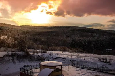 a view of a snow covered field with the sunset at Ma-Bebe SPA Suite - Thermal Jacuzzi and Family Comfort in Pchelin