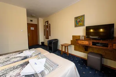 a hotel room with two beds and a flat screen tv at Kap House Family Hotel in Bansko