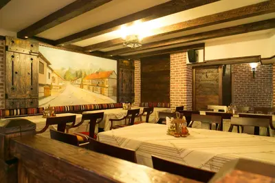 a restaurant with tables and chairs and a painting on the wall at Kap House Family Hotel in Bansko