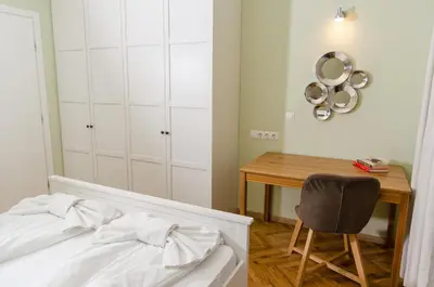 a bedroom with a bed and a desk and a chair at VIP Apartments Sofia in Sofia
