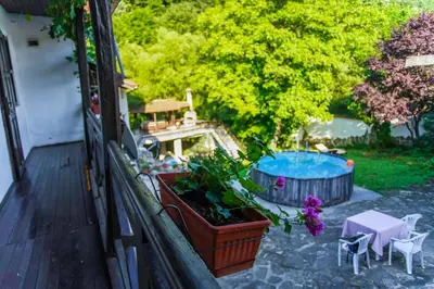a balcony with a tub and some plants and a table at Guest House Planinska Sreshta in Balkanets