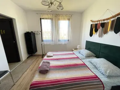 a bedroom with a large bed with a striped blanket at Kassandrova Guest House & Spa in Bratsigovo