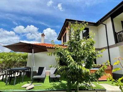 a patio with a table and chairs and an umbrella at Kassandrova Guest House & Spa in Bratsigovo