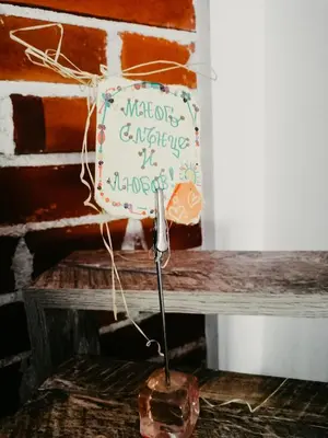 a sign sitting on top of a wooden bench at Kassandrova Guest House & Spa in Bratsigovo