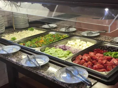 a buffet with many trays of different types of food at Flora Hotel - Apartments in Borovets