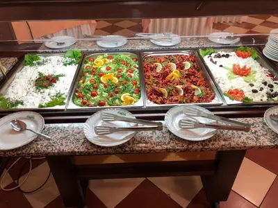 a buffet table with many trays of food on it at Flora Hotel - Apartments in Borovets