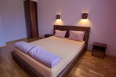 a bedroom with a large bed with two pillows at Guest House Villa Bozhenitsa in Bozhenitsa