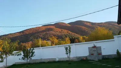 a mountain in the background with a white wall at Villa Gardenia in Sapareva Banya