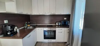 a small kitchen with white cabinets and a sink at Villa Gardenia in Sapareva Banya