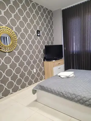 a bedroom with a bed and a wall with a mirror at Studio M in Plovdiv