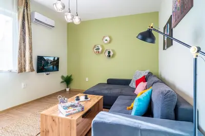 a living room with a blue couch and a coffee table at Madrid 90 Sq M 2BDR w Parking Spot near Metro, Serdika Mall in Sofia