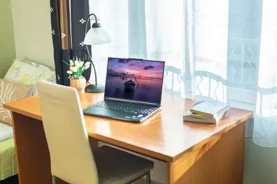 a laptop computer sitting on a wooden desk at Madrid 90 Sq M 2BDR w Parking Spot near Metro, Serdika Mall in Sofia