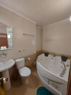 a bathroom with a tub and a toilet and a sink at Elegant Complex in Pazardzhik