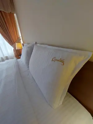 a white bed with a pillow on top of it at Elegant Complex in Pazardzhik