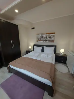 a bedroom with a large bed with two night stands at Elegant Complex in Pazardzhik