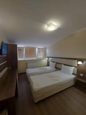 a bedroom with two beds and a flat screen tv at Elegant Complex in Pazardzhik