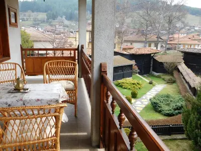 a balcony with a table and chairs and a view at Family Vacation Home Topolnitza in Koprivshtitsa