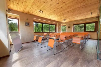 a classroom with tables and chairs in a room with windows at PinusVillas Private Jacuzzi & Phyto-Sauna in Zheleznitsa