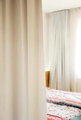 a bedroom with white curtains and a bed at Architectural City Loft in Sofia