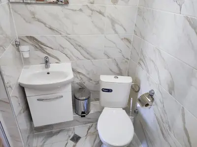 a white bathroom with a toilet and a sink at Guest Rooms Filipopol in Plovdiv
