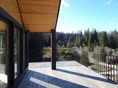 a screened porch with a view of the woods at High Five Villas in Pamporovo