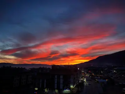 a sunset in a city with a red sky at Bansko Royal Towers Hotel in Bansko