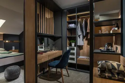 a bedroom with a closet with a desk and a chair at Rosslyn Thracia Hotel Sofia in Sofia