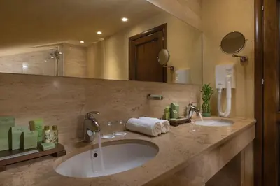 a bathroom with two sinks and a large mirror at Rosslyn Thracia Hotel Sofia in Sofia