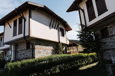an old stone house with a roof and windows at Villa Maria, Complex Aleksandria in Dobrinishte